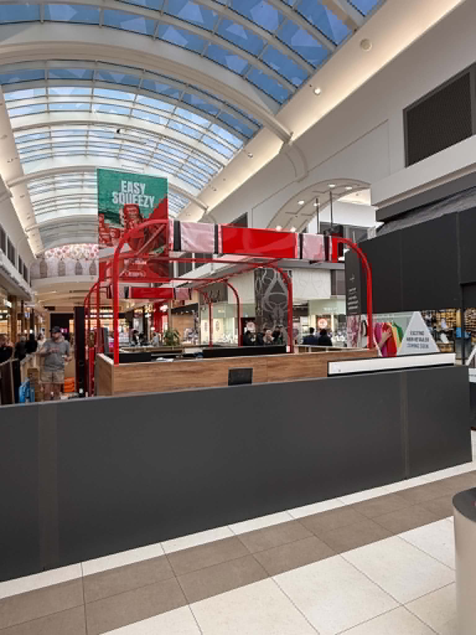 Wide view of the Northland Lotto kiosk and red overhead steel framing