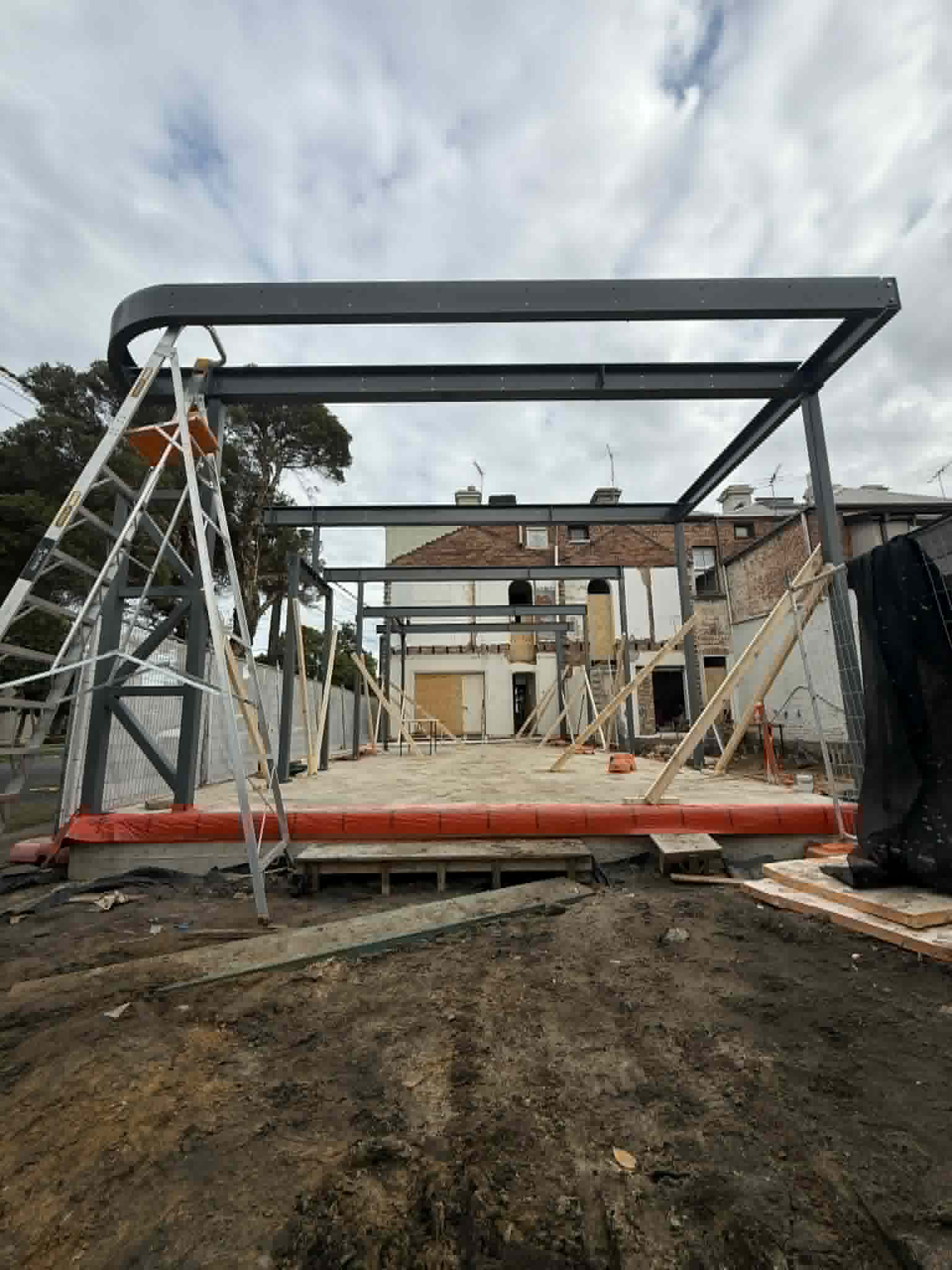 Steel frame above a concrete slab and scaffolding at Albert Park