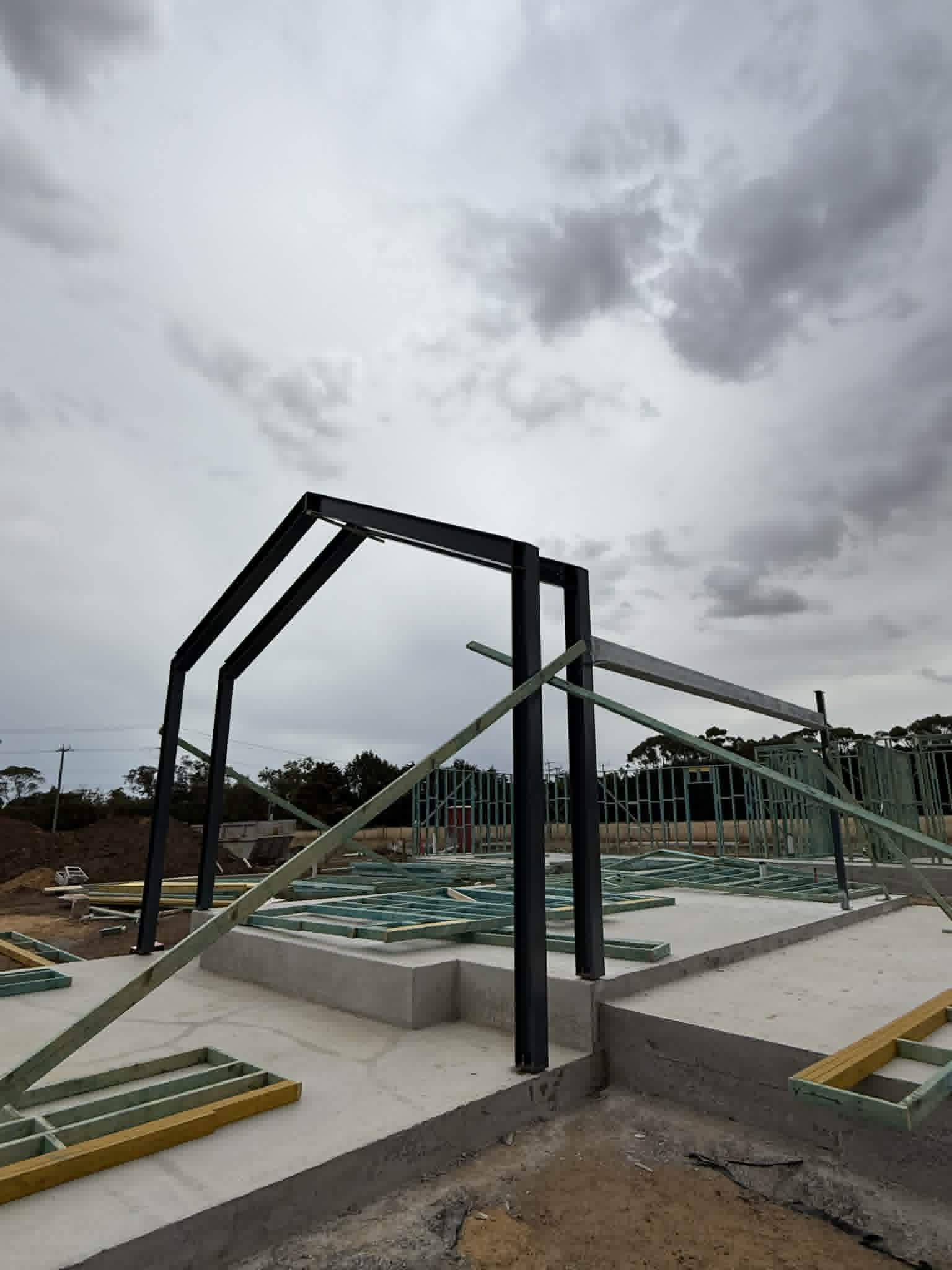 Dark steel portal frames above concrete foundations at Waurn Ponds