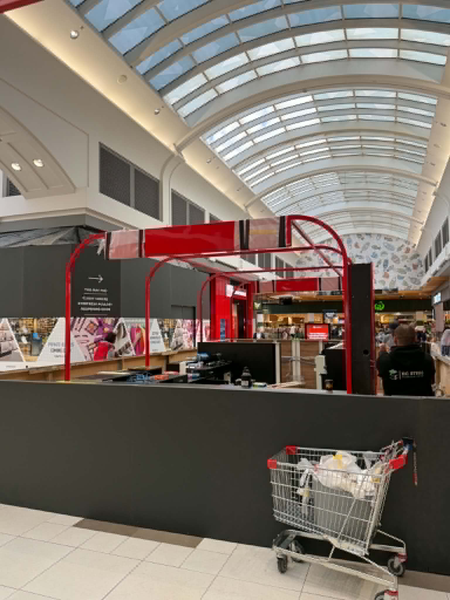 Red steel framework above the Northland Lotto kiosk in a shopping centre