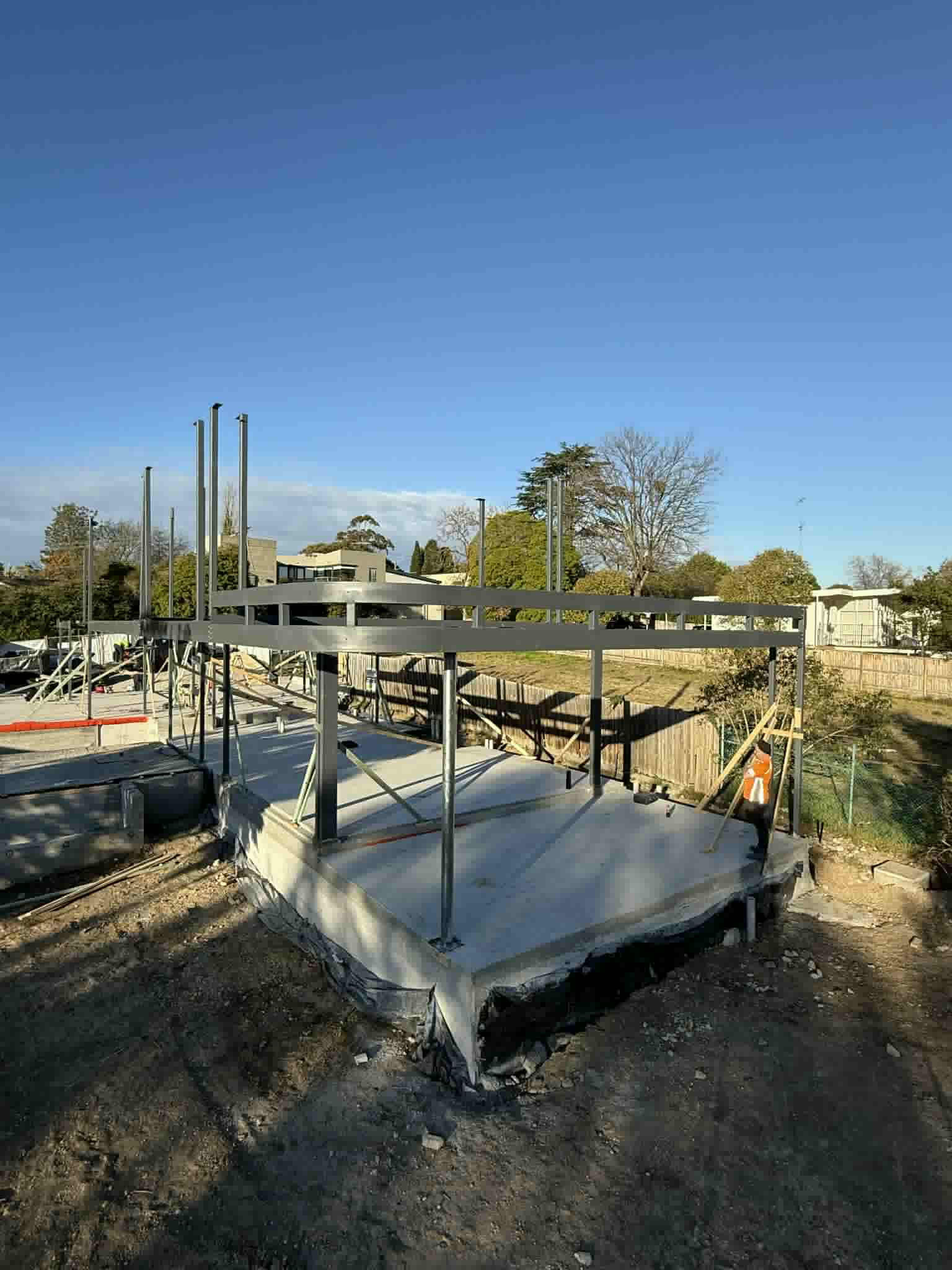 Steel beams and columns erected above a concrete slab at Ivanhoe