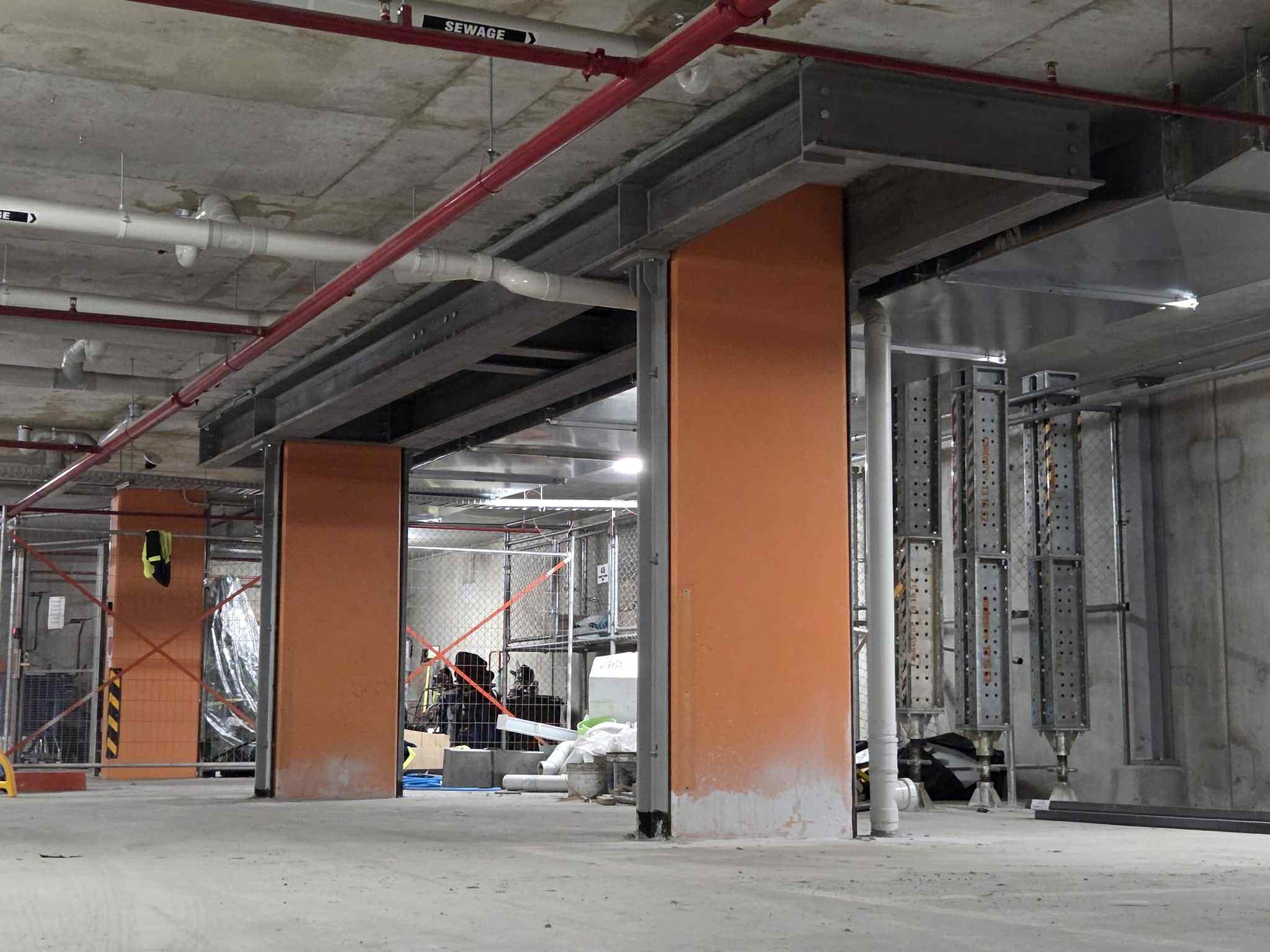 Steel framing around orange piers inside the Glen Waverley construction site