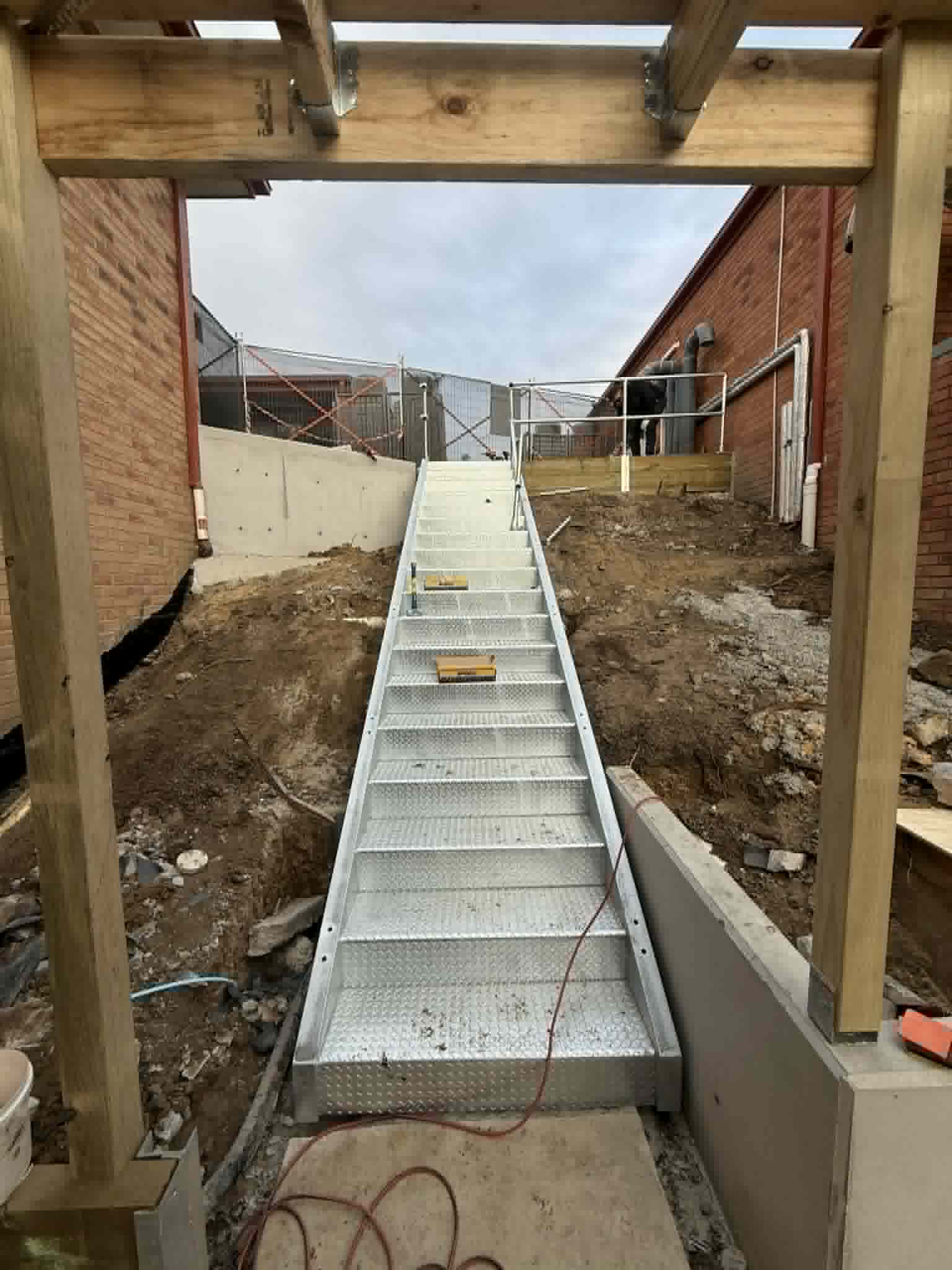 Steel walkway extending between brick buildings at Kalimna