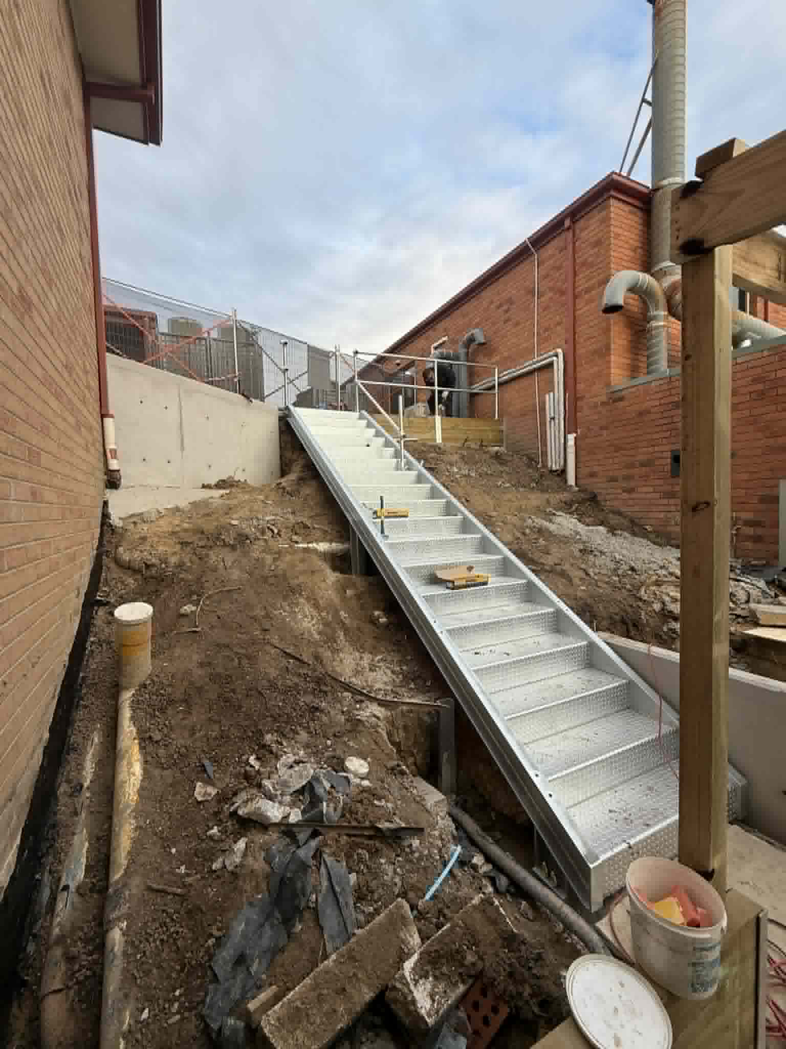 Long steel walkway with handrails between buildings at Kalimna