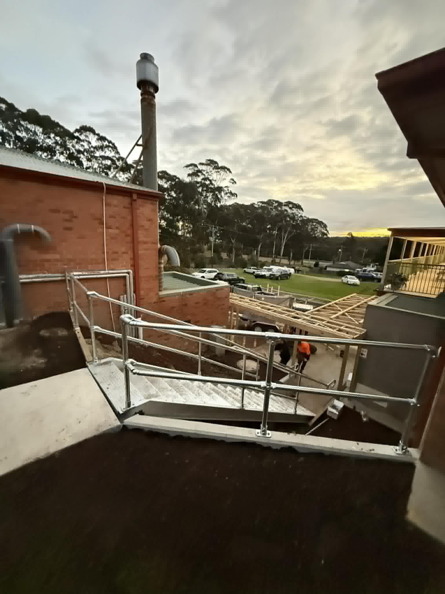 Steel landing and handrails beside brick buildings at Kalimna