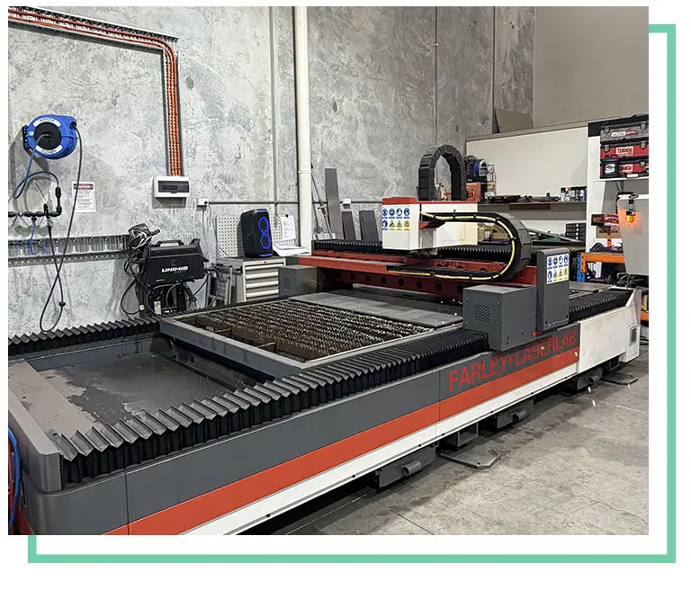 Industrial CNC cutting table and gantry inside a metal fabrication workshop